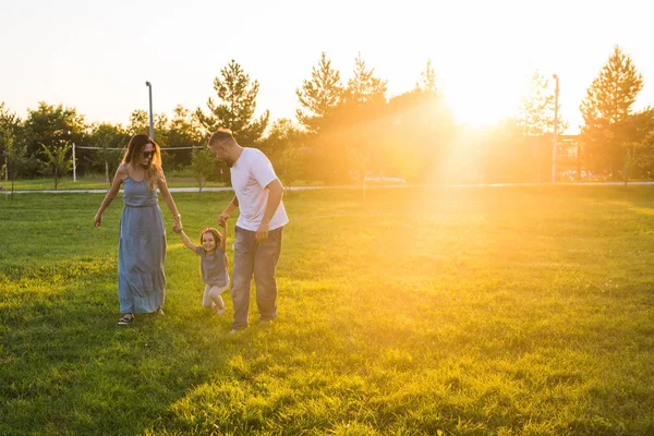 Amistosa familia caminando en el parque y divertirse juntos — Foto de Stock