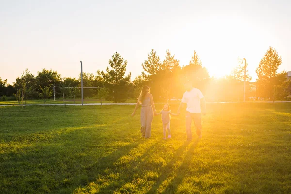 Freundliche Familie, die im Park spazieren geht und gemeinsam Spaß hat — Stockfoto