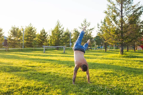 Yoga, fitness and healthy lifestyle concept - man doing a handstand on summer nature — Stock Photo, Image