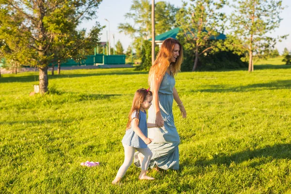 Family and child concept - Mother and daughter walking in the park and enjoying the beautiful nature. — Stock Photo, Image