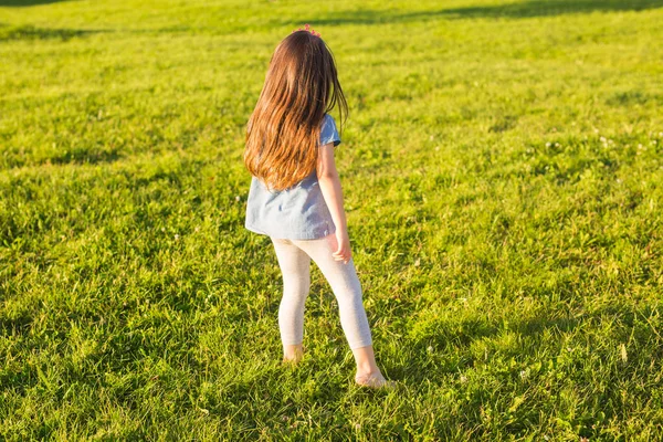 Маленька щаслива дівчинка розважається в літньому парку . — стокове фото