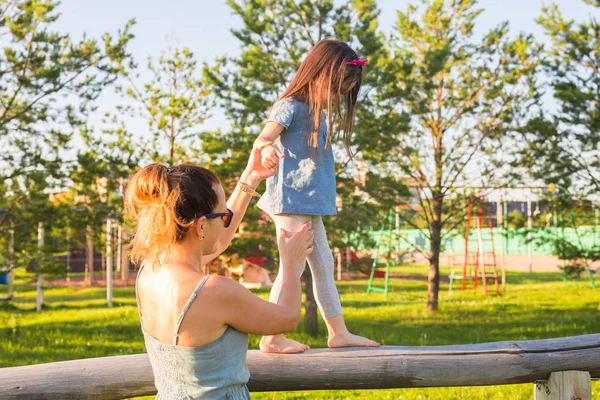 Concepto de familia e hijo - Madre e hija caminando y jugando en el parque y disfrutando de la hermosa naturaleza . —  Fotos de Stock