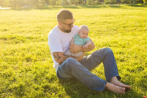 Heureux père tenant bébé fils sur la nature. Concept de famille heureuse, fête des pères et des enfants . — Photo