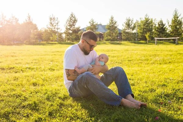 Feliz padre sosteniendo bebé hijo en la naturaleza. Concepto de familia feliz, día del padre y el niño . — Foto de Stock