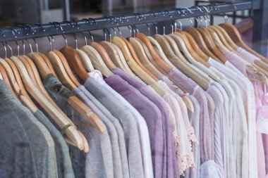 Ahşap askılarda farklı renkte moda kıyafetleri.