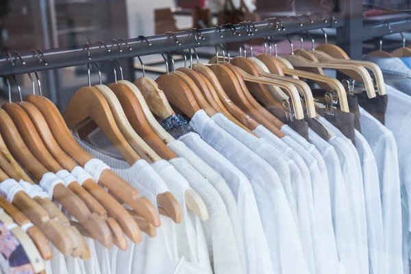 Elección de ropa de moda de diferentes colores en perchas de madera — Foto de Stock