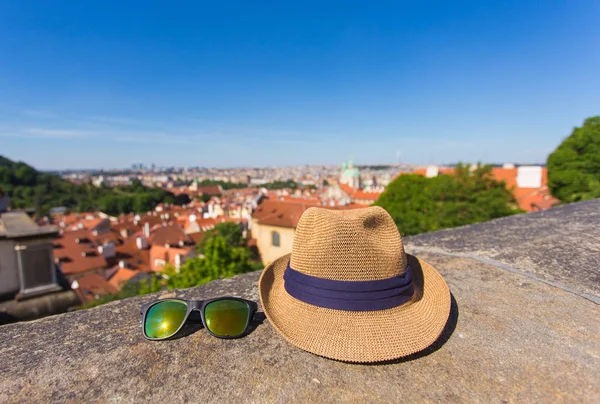 Turismo, viajes, vacaciones y concepto de verano - Sombrero y gafas de sol sobre un fondo de la ciudad vieja . — Foto de Stock