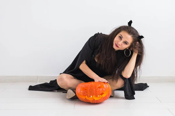 Halloween-Konzept - glückliche Hexe mit Kürbis-Laterne Stockbild