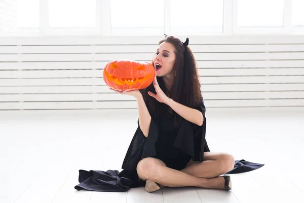 Portret van een stijlvolle brunette vrouw met halloween pompoen — Stockfoto