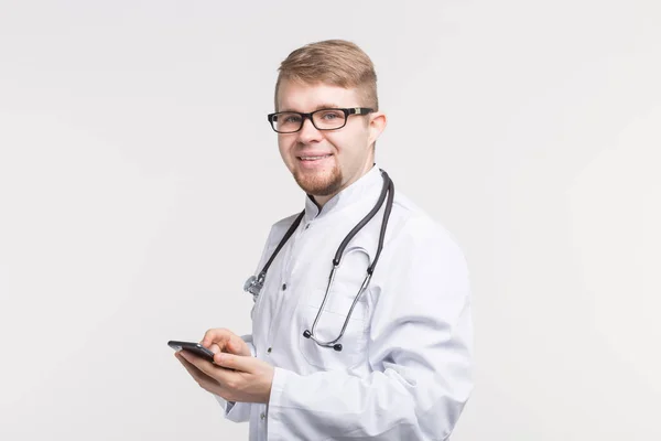 Πορτρέτο του αρσενικό ο γιατρός με το τηλέφωνο στα χέρια σε λευκό φόντο — Φωτογραφία Αρχείου