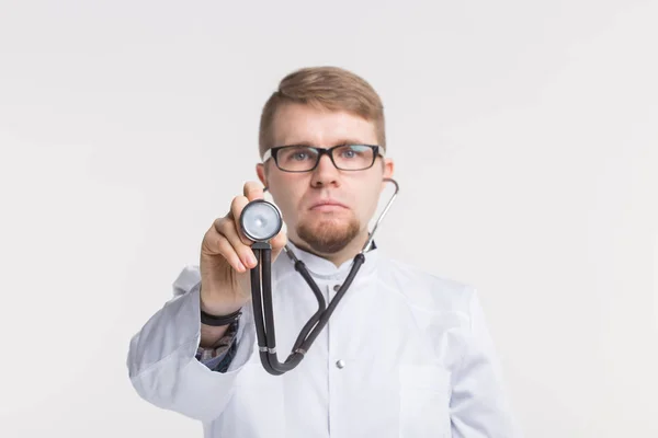 Портрет молодого врача-мужчины со стетоскопом на белом фоне — стоковое фото
