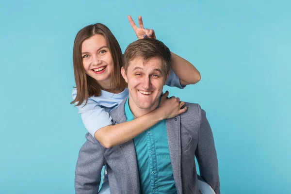 Pareja joven divertida en sesión de estudio con fondo azul . — Foto de Stock