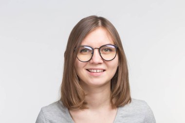 Mutlu kahverengi saçlı kadın beyaz arka plan üzerinde bir gözlük gülen portre