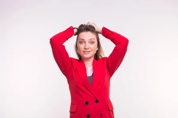 Surpreendido sardento jovem mulher vestindo terno vermelho no fundo branco — Fotografia de Stock