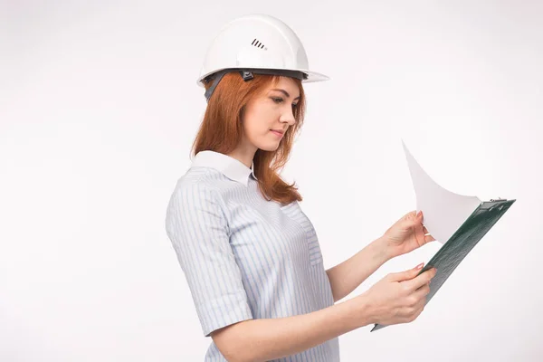 Concepto de arquitecto, trabajador y agente inmobiliario: mujer constructora o ingeniera con documentos sobre fondo blanco con espacio para copias — Foto de Stock