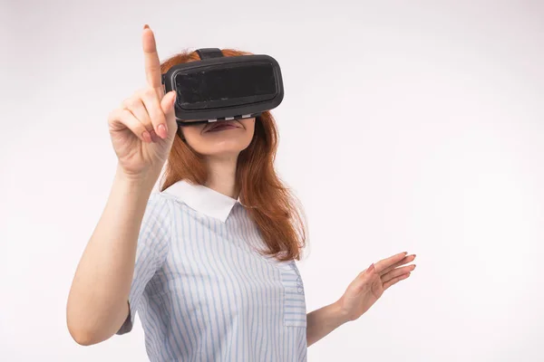 Жінка вказує, що натискає сенсорний екран віртуальною реальністю на білому тлі. Концепція пристрою для скляних окулярів VR — стокове фото