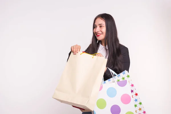 Mujer asiática feliz con labios rojos sosteniendo bolsas de compras sobre fondo blanco con espacio de copia — Foto de Stock