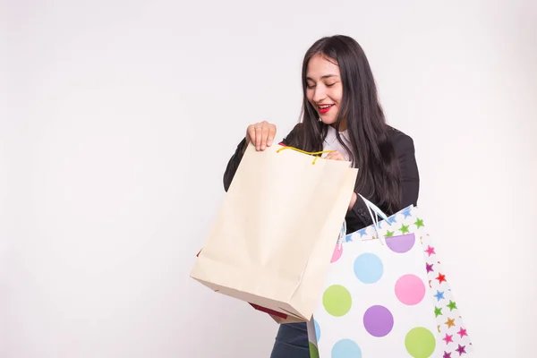 Retrato de jovem morena feliz com sacos de compras no fundo branco com espaço de cópia — Fotografia de Stock