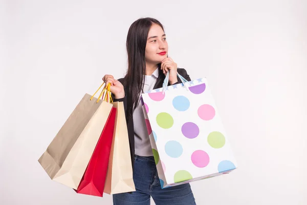 Retrato de jovem morena feliz com sacos de compras no fundo branco — Fotografia de Stock