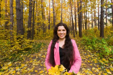 Sezon, eğlenceli ve zevk kavramı - pembe ceket sonbahar buket tutan genç güzel kadın bırakır