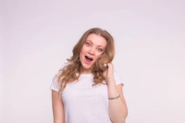 Mode, Stil und People-Konzept - junge und schöne Frau posiert überraschend auf weißem Hintergrund — Stockfoto