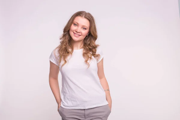 Jonge lachende vrouw poseren op witte achtergrond met kopie ruimte — Stockfoto