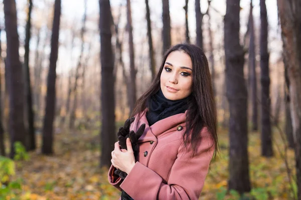 Menschen, Saison- und Herbstkonzept - Porträt einer jungen attraktiven langhaarigen brünetten Frau im Herbstpark — Stockfoto