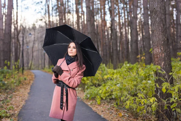 Pessoas, estação e conceito de moda - bela jovem no parque de outono com guarda-chuva — Fotografia de Stock