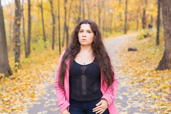 Portrait d'une belle et rêveuse jeune femme aux longs cheveux ondulés dans le parc d'automne — Photo