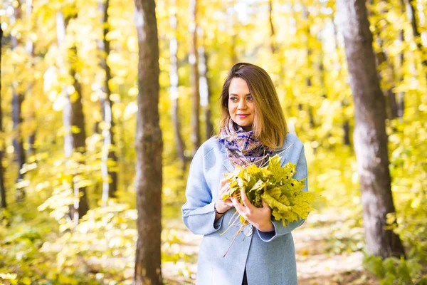 Natura, piękno, koncepcja ludzie - portret cute młoda kobieta kolorowy Bukiet żółtych liści jesienią w parku jesienią — Zdjęcie stockowe