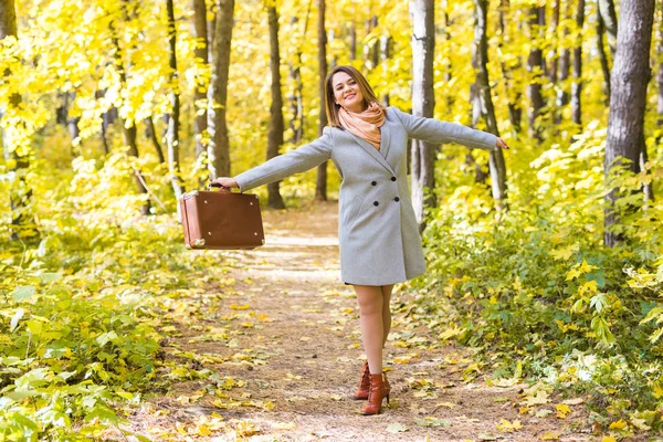 Estação, natureza e conceito de pessoas - mulher no parque de outono posando com mala — Fotografia de Stock