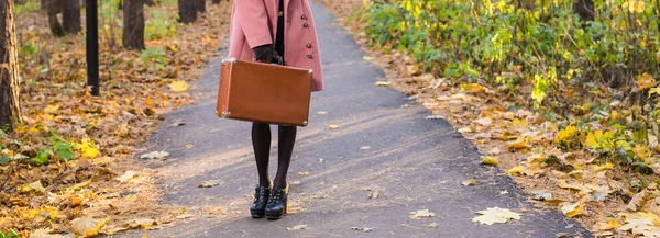 Automne, mode, concept de personnes - gros plan sur une femme avec une valise rétro marron marchant dans le parc d'automne — Photo