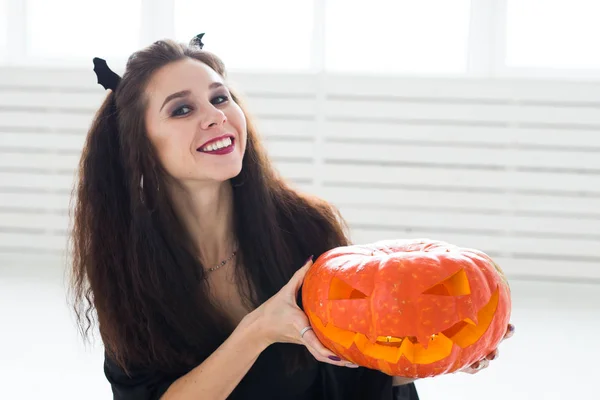 Halloween y el concepto de mascarada - Hermosa joven posando con calabaza Jack-o-linterna . Fotos de stock libres de derechos