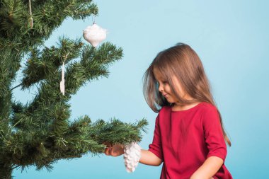 Noel, çocukluk ve insanlar kavramı - küçük kız Noel ağacı süsleme