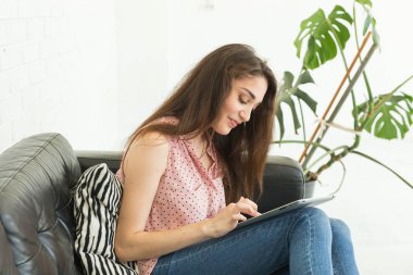 Teknolojileri, insanlar kavramı - kanepe ve tablet izlerken veya net sörf ve gülümseyen üzerinde oturan genç kadın