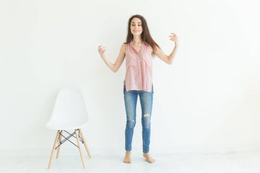 Gülümseyen genç esmer kadın beyaz odada dans tam uzunlukta portresi