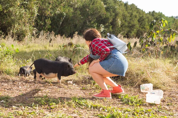 Happy young woman plays with little wild boars on nature. — Stock Photo, Image