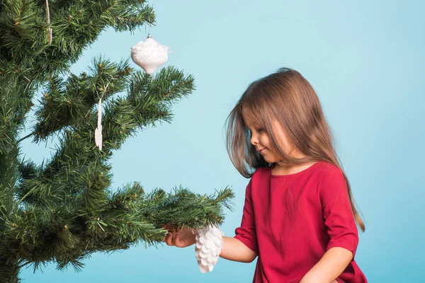 Noel, çocukluk ve insanlar kavramı - küçük kız Noel ağacı süsleme