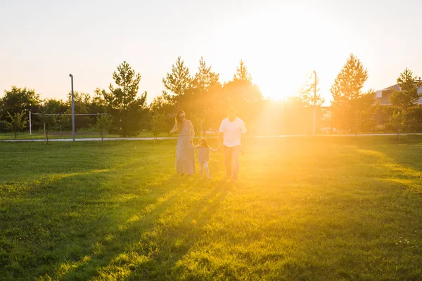 Дружелюбная семья гуляет по парку и веселится вместе — стоковое фото