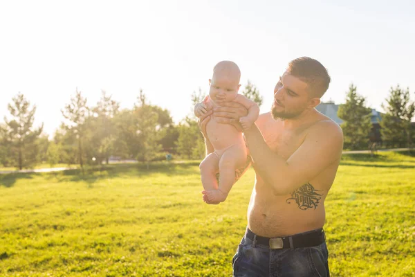 Buon padre che tiene in braccio il bambino sulla natura. Concetto di famiglia felice, giorno di padri e bambino . — Foto Stock