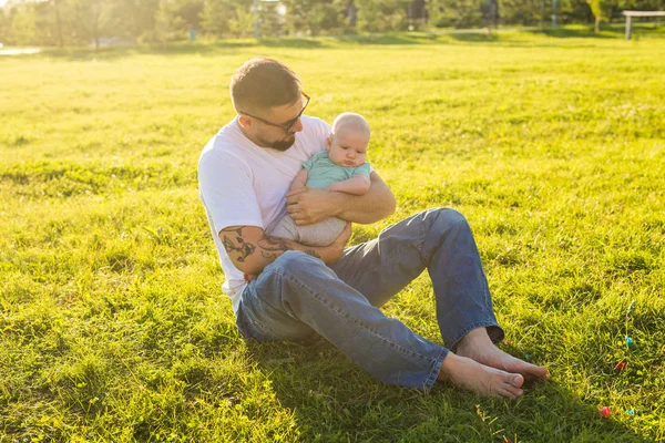 Happy father holding baby son on nature. Concept of happy family, fathers day and child. — Stock Photo, Image