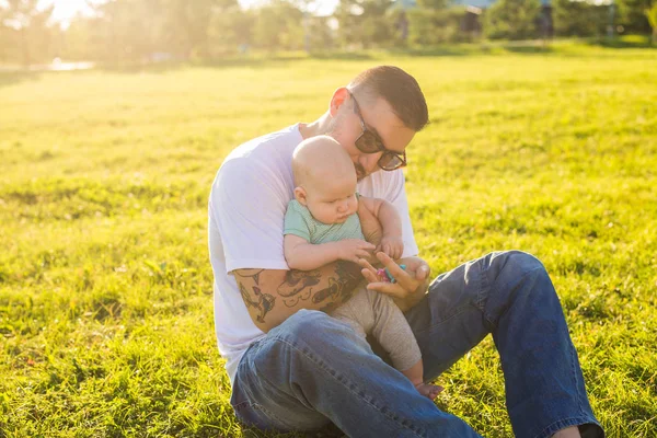 Heureux père tenant bébé fils sur la nature. Concept de famille heureuse, fête des pères et des enfants . — Photo