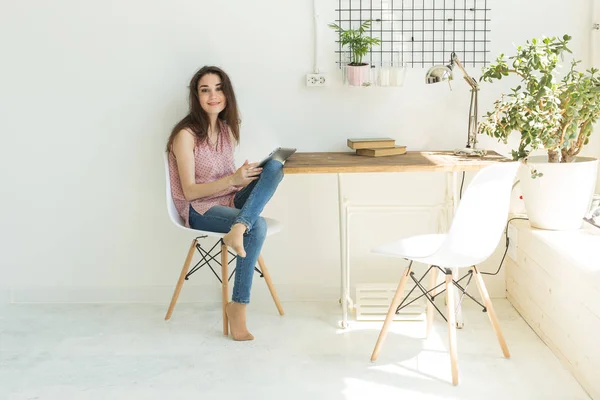 Tecnologia e concetto di persone - Giovane bella donna seduta al tavolo bianco con tablet digitale — Foto Stock