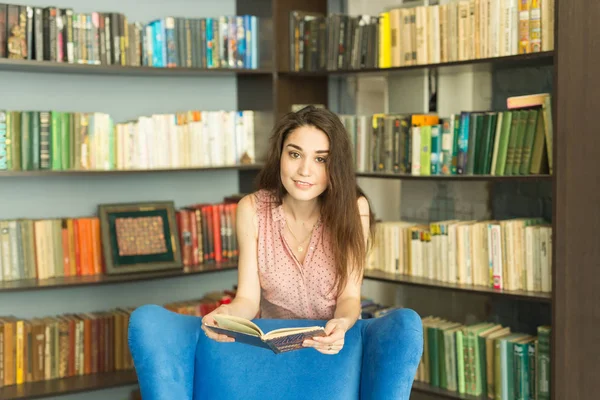 Persone, istruzione e concetto di conoscenza - Donna che legge libro in biblioteca — Foto Stock