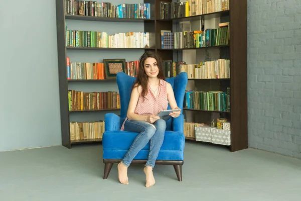 Vrije tijd, mensen en home concept - Happy ontspannen vrouw in home bibliotheek — Stockfoto