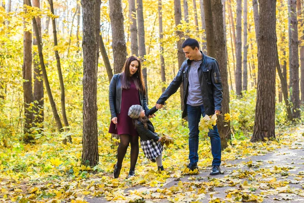 Rodzicielstwa, upadku i ludzi pojęcie - młoda rodzina szczęśliwy w jesienny park — Zdjęcie stockowe