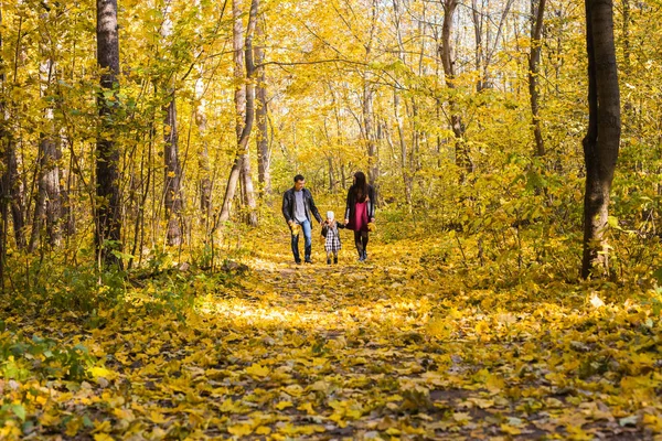 Queda, natureza e conceito de família - caminhada familiar feliz no parque de outono — Fotografia de Stock