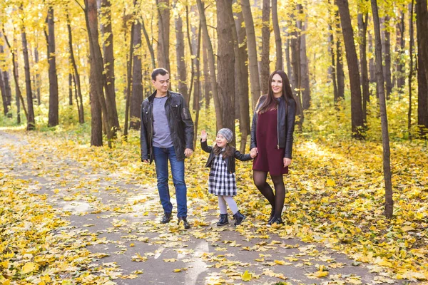 Familie, Herbst, Menschen-Konzept - junge Familie spaziert an einem Herbsttag im Park — Stockfoto