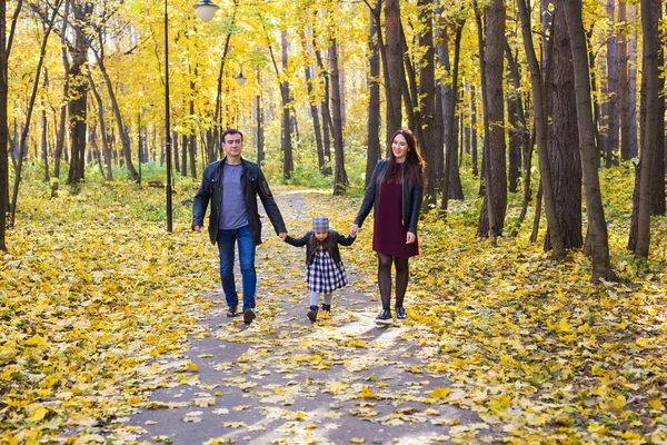Concepto de paternidad, caída y personas - familia joven feliz en el parque de otoño — Foto de Stock