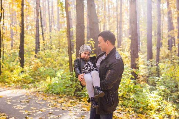 Family, autumn, people concept - father and daughter walking in autumn park